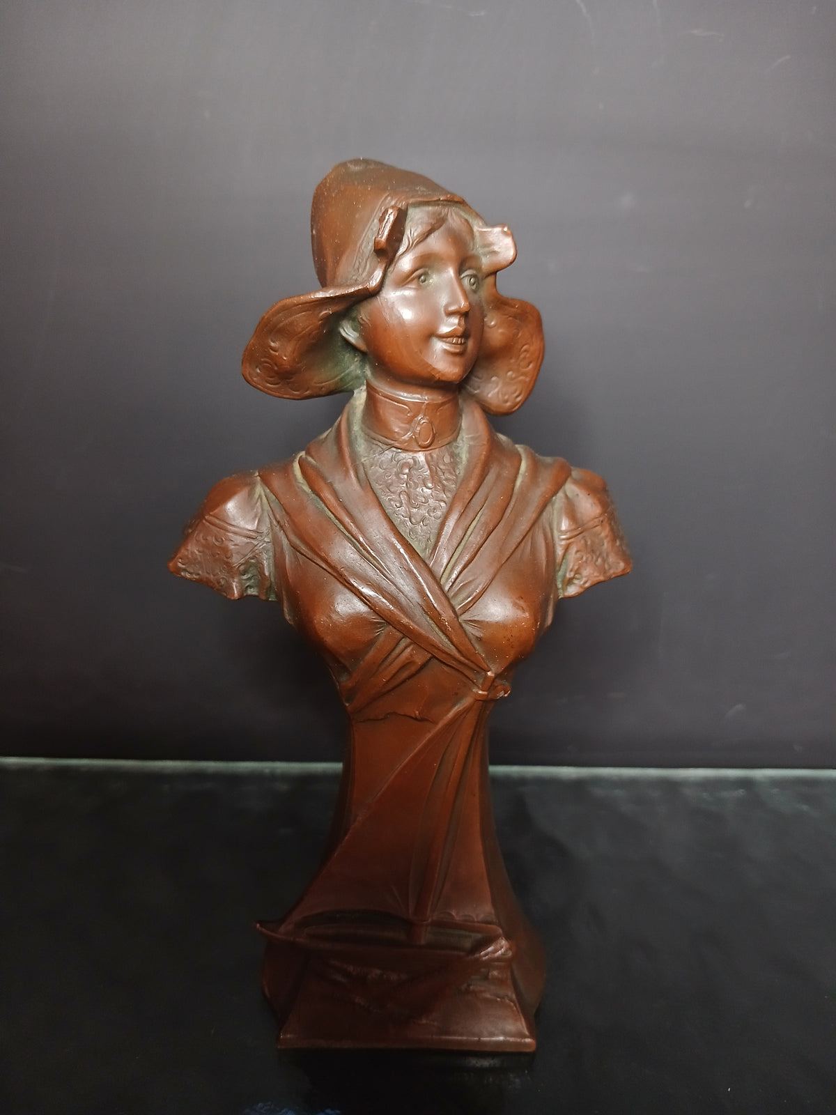 Buste la femme souriante, coiffée d'un chapeau traditionnel breton