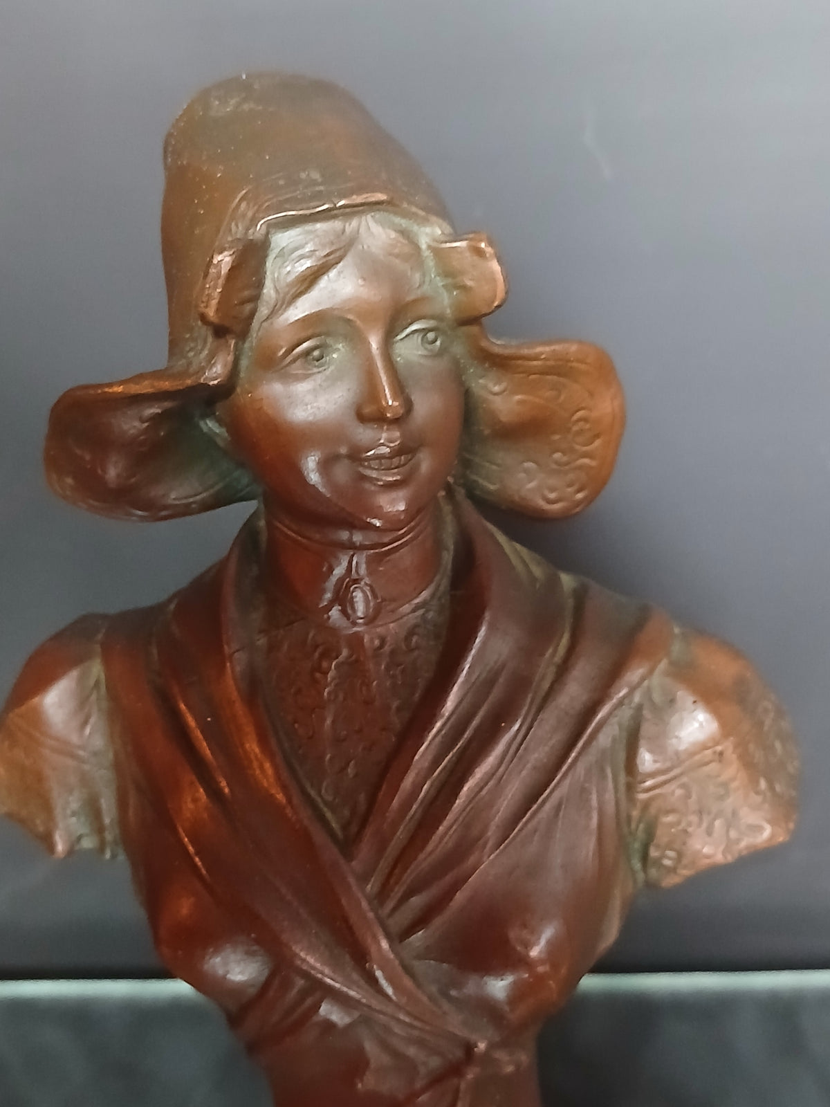 Buste la femme souriante, coiffée d'un chapeau traditionnel breton